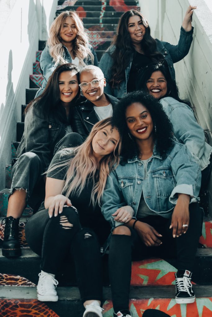 Gruppe von Frauen sitzt auf bunter Treppe